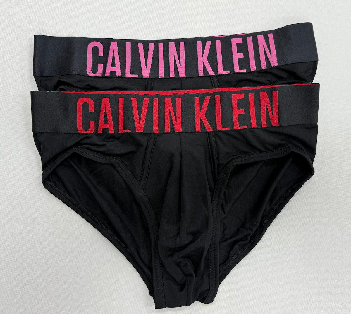 Black Calvin Klein underwear with red and pink logo on a white background